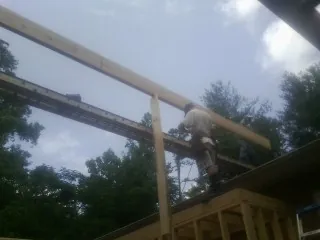 Carpenter setting a ridge beam over a new addition frame — Ice Dam Removal by Roofing Brothers in Ardara