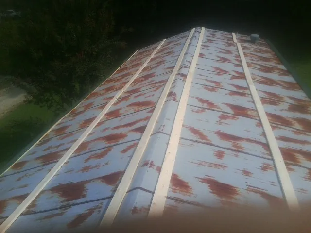 Rusted metal roof panels with new wood purlins before replacement — Storm Damage Roof Repair in Ardara by Roofing Brothers