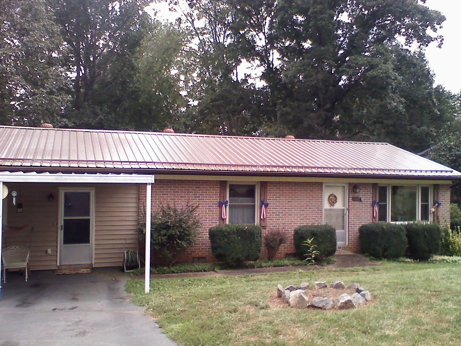 Bronze metal roof and carport on a brick ranch home — Roof Repair work by our crew in Ardara